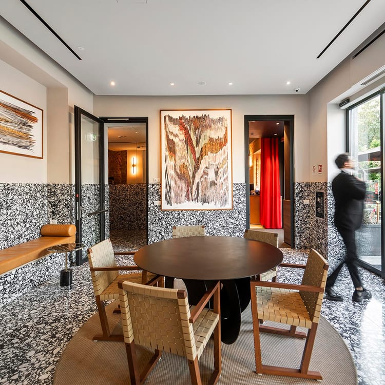 Detalle del vestíbulo con mesa y sillas del Hotel Milu Milán