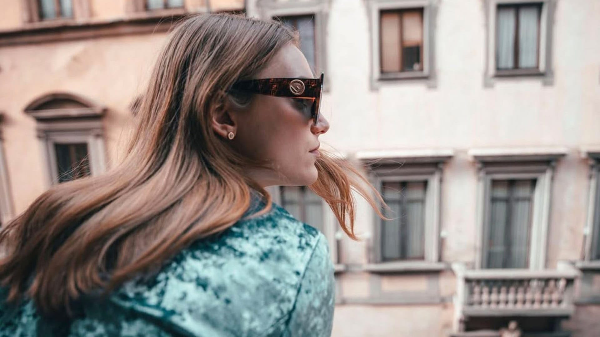 Chica con gafas de sol mirando por la ventana