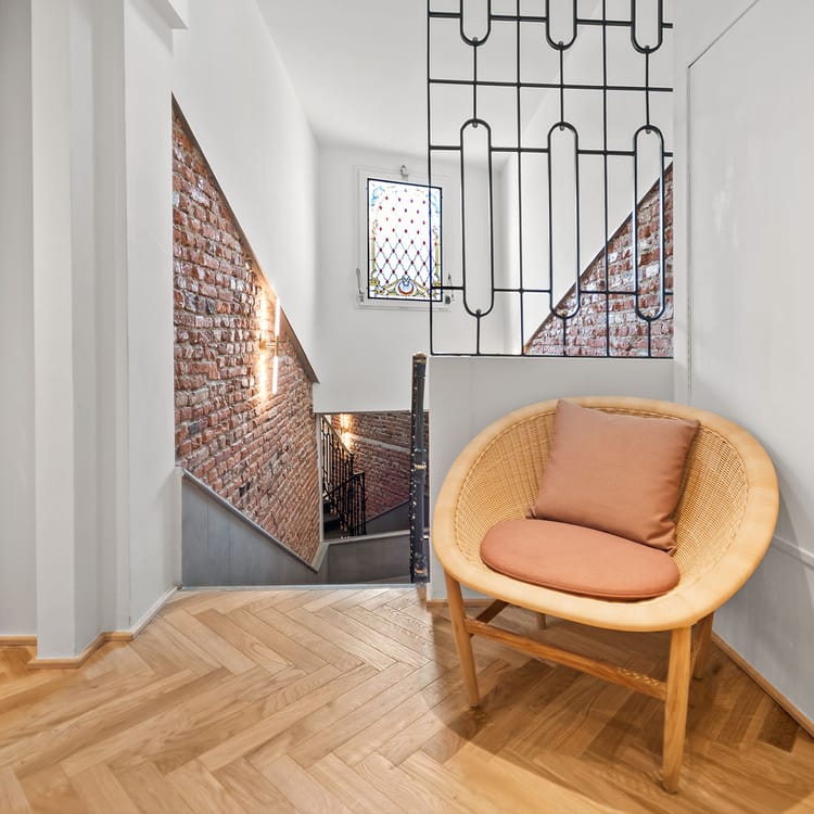 Detalle de los pasillos interiores del Hotel Milu Milán con sillón